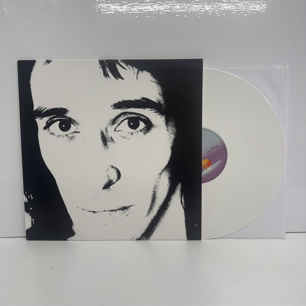 Vinyl record with a stark black-and-white close-up portrait of a man’s face, showing intense eyes and sharp features.